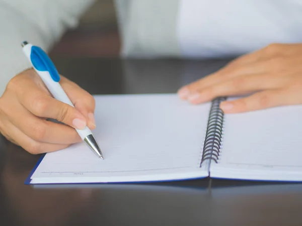 Escritura manual de mujer de primer plano con bolígrafo blanco en mesa de trabajo. Concepto de empresa y educación . —  Fotos de Stock