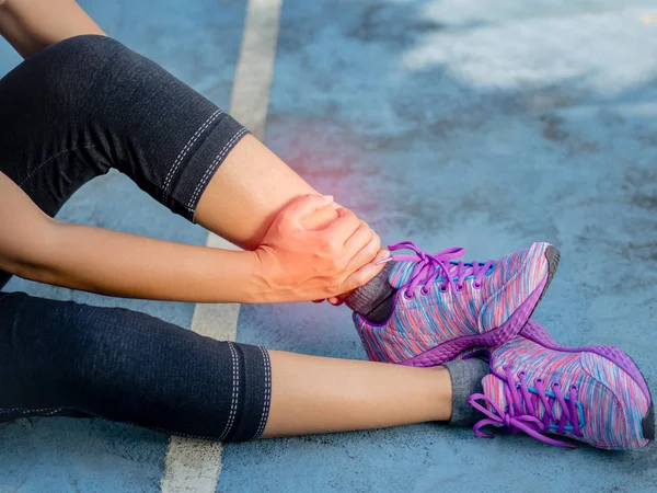 Νεαρή γυναίκα που πάσχουν από έναν τραυματισμό στον αστράγαλο ενώ άσκηση και τρέξιμο. Αθλητισμός άσκηση τραυματισμοί έννοια. — Φωτογραφία Αρχείου