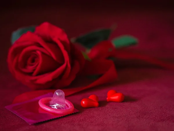 Niski klucz prezerwatywy z czerwonych róż i serc na różowym tle. Zapisz seks, Rodzina planu i koncepcji Valentine. — Zdjęcie stockowe