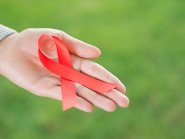 Kırmızı kurdele HIV, Dünya AIDS günü bilinçlendirme şerit tutan kadın eller. Sağlık ve tıp kavramı.