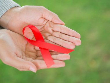Kırmızı kurdele HIV, Dünya AIDS günü bilinçlendirme şerit tutan kadın eller. Sağlık ve tıp kavramı.