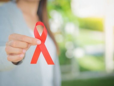 Tatlı kadın el holding kırmızı kurdele HIV, Dünya AIDS günü bilinçlendirme şerit. Sağlık ve tıp kavramı.