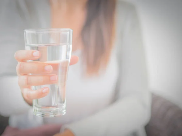 幸せな美しい若い女性は彼女の手で水を飲むガラスを保持しています。医療コンセプト. — ストック写真