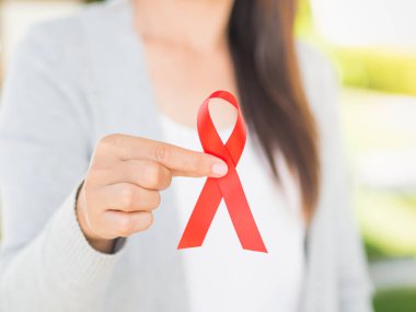 Tatlı kadın el holding kırmızı kurdele HIV, Dünya AIDS günü bilinçlendirme şerit. Sağlık ve tıp kavramı.
