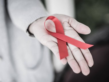 Kadın el holding kırmızı kurdele HIV, Dünya AIDS günü bilinçlendirme şerit retro tarzı. Sağlık ve tıp kavramı.