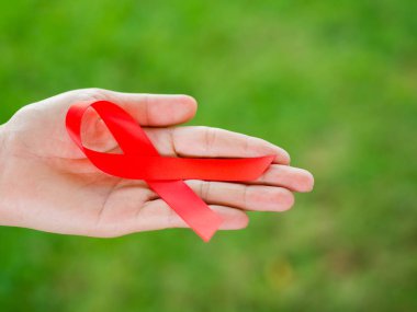 Tatlı kadın el holding kırmızı kurdele HIV, Dünya AIDS günü bilinçlendirme şerit. Sağlık ve tıp kavramı.