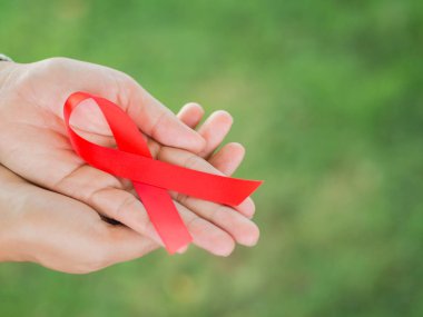 Kırmızı kurdele HIV, Dünya AIDS günü bilinçlendirme şerit tutan kadın eller. Sağlık ve tıp kavramı.
