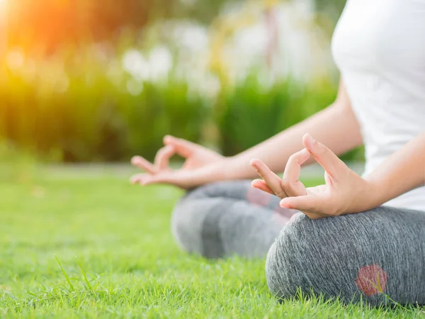 Dedo de yoga de mujer de primer plano que actúa sobre las manos en un fondo de enfoque suave con la naturaleza circundante. Concepto de estilo de vida saludable y relajación . — Foto de Stock