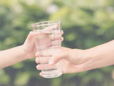 Closeup vintage kadın el parkta çocuk bardak taze su verilmesi. İçki ve sağlık kavramı.