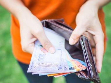 Tatlı kadın el deri cüzdan para koyarak. İş dünyası ve finans, para tasarrufu kavramı.