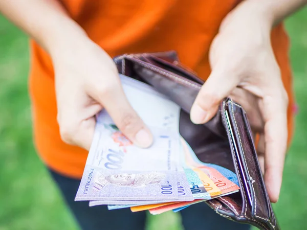 Tatlı kadın el deri cüzdan para koyarak. İş dünyası ve finans, para tasarrufu kavramı.