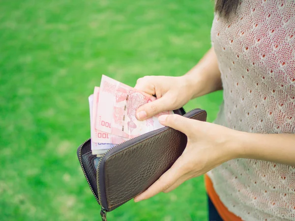 Tatlı kadın el deri cüzdan para koyarak. İş dünyası ve finans, para tasarrufu kavramı.