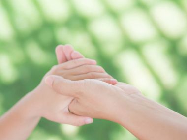 kadın tutar güzel bir çocuk el kapatın. Anne ve oğlu yeşil alan arka planda elele. İnsanlar, sadaka ve aile kavramı.