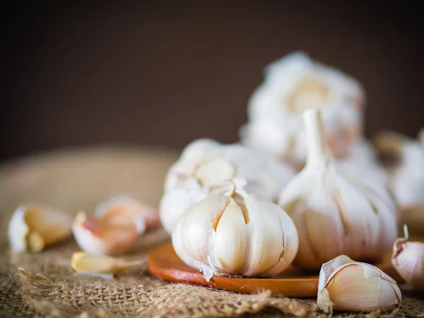 Closeup garlic clove, garlic bulb in wicker basket place on hemp sack background