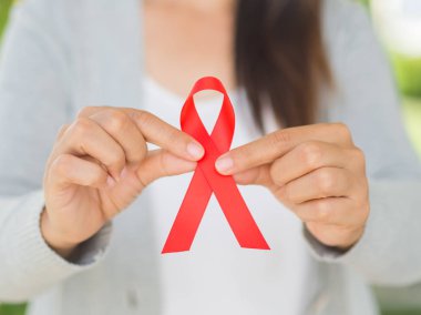 Tatlı kadın el holding kırmızı kurdele HIV, Dünya AIDS günü 