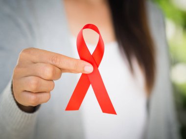 Tatlı kadın el holding kırmızı kurdele HIV, Dünya AIDS günü 