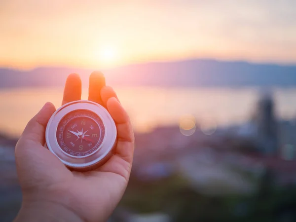 Nahaufnahme Hand hält Kompass mit Berg und Sonnenuntergang Himmel — Stockfoto