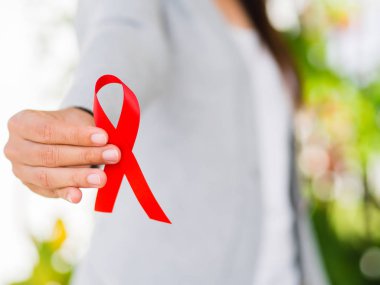 Tatlı kadın el holding kırmızı kurdele HIV, Dünya AIDS günü 