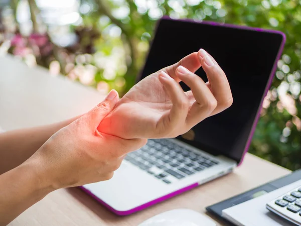 Mujer de primer plano sosteniendo su dolor de muñeca de usar la computadora. Síndrome de oficina —  Fotos de Stock