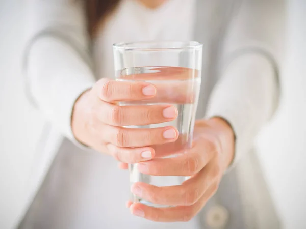 彼女の手で水を飲むガラスを保持している若い女性. — ストック写真