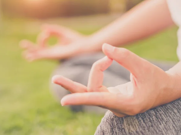 Foco suave del dedo del yoga de la mujer que actúa en manos con la naturaleza circundante fondo. Concepto de estilo de vida saludable y relajación . — Foto de Stock