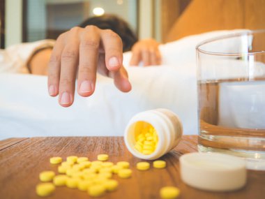 Hasta bir kadın yüksek ateşle yatakta yatan bir battaniye ile örtülü 