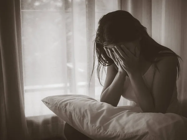 Hitam dan putih tertekan wanita menangis sambil duduk sendirian — Stok Foto