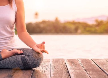 Ellerinde günbatımı sırasında hareket kadın yoga parmak yumuşak odak... Sağlıklı yaşam tarzı ve gevşeme kavramı.