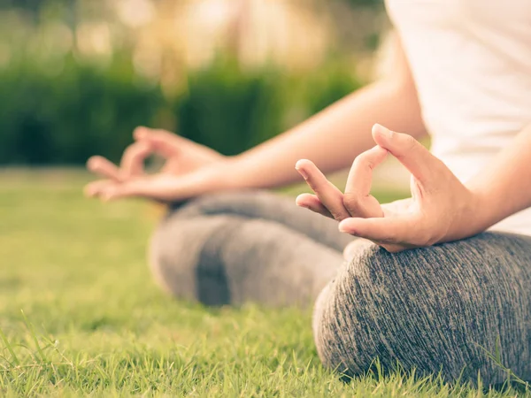 Estilo retro del dedo del yoga de la mujer que actúa en las manos con la naturaleza que rodea el fondo. Concepto de estilo de vida saludable y relajación . — Foto de Stock