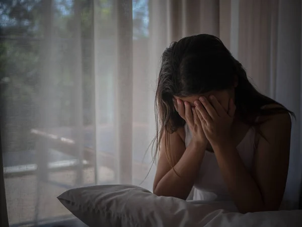 Närbild deprimerad kvinna gråter medan du sitter ensam på trägolvet. Sorgliga kvinna koncept. — Stockfoto