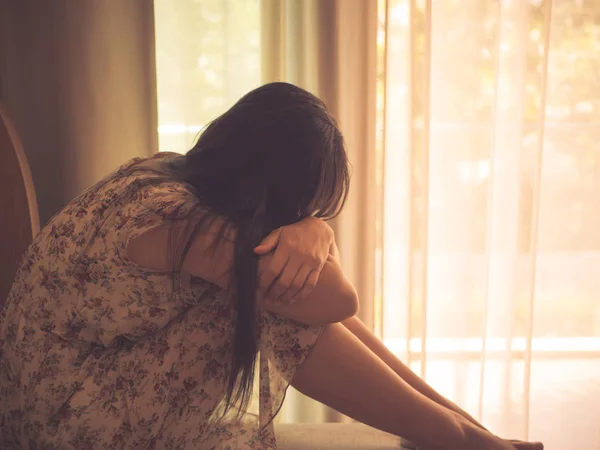 Mujer deprimida abrazar su rodilla y llorar mientras está sentada sola — Foto de Stock