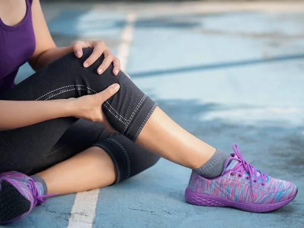 Ung kvinna lider en vristskada medan du tränar — Stockfoto