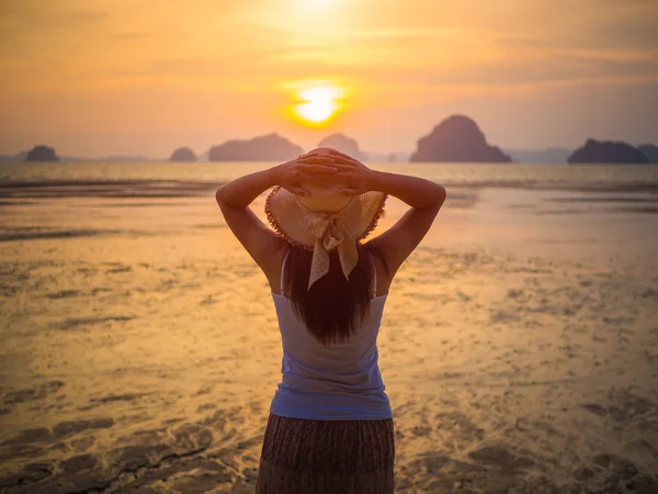 Kadın şapkası güneşin altında Kollarını açarak denize yakın
