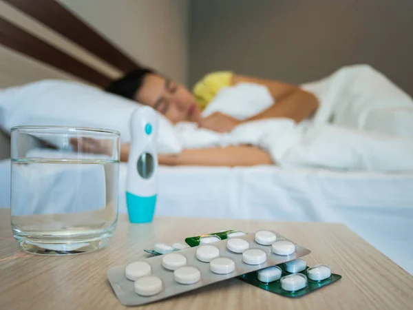 Zieke vrouw bedekt met een deken liggen in bed met hoge koorts — Stockfoto