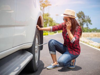 Üzgün kadın tekerlek kaldıramadı. Garaja telefona çağırma ve onarım yardım istedi.