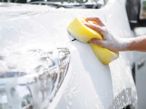車を洗う黄色いスポンジで女性の手 — ストック写真