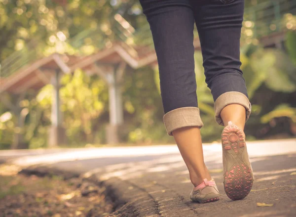 Doğru yol kenarında yürüyen Closeup kadın. Adım kavramı.