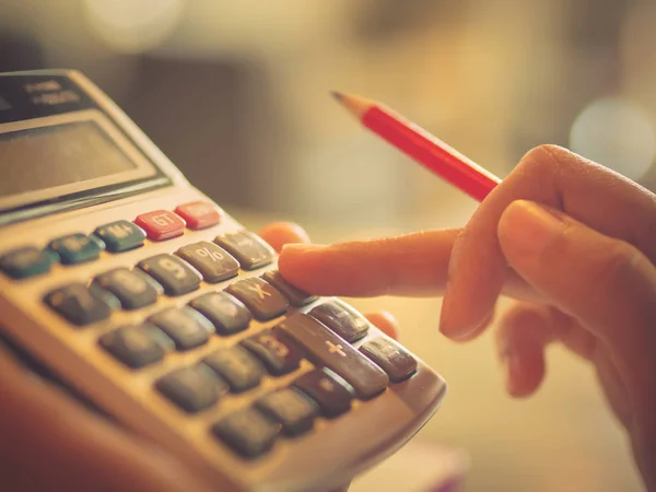 Fechar mão mulher de negócios usando uma calculadora com lápis vermelho — Fotografia de Stock