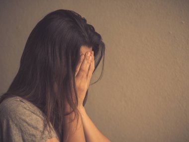 Boş bir odada tek başına oturan üzgün kadın retro tarzı.