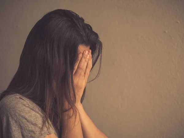 Boş bir odada tek başına oturan üzgün kadın retro tarzı.