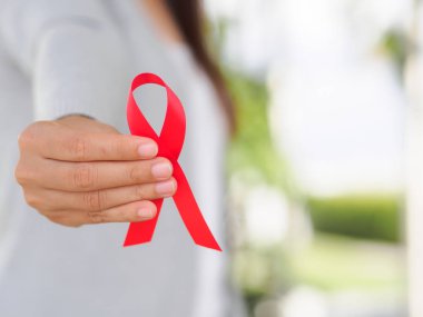 Tatlı kadın el holding kırmızı kurdele HIV, Dünya AIDS günü 