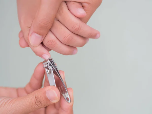 Actividad familiar madre uñas cortadas a mano para niños mediante el uso de cortauñas, con enfoque selectivo . — Foto de Stock