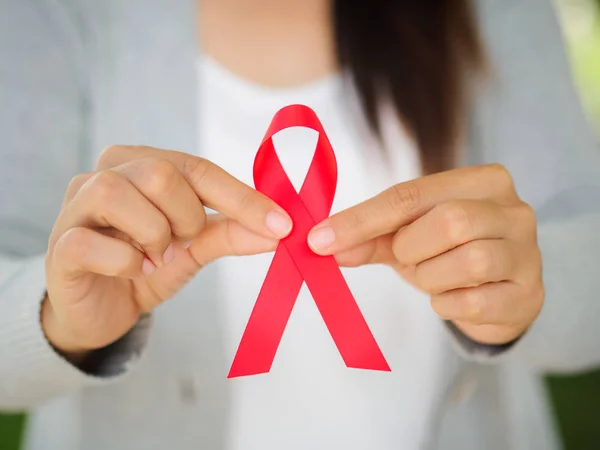 Mujer sosteniendo la cinta roja VIH, conciencia del día mundial del SIDA — Foto de Stock