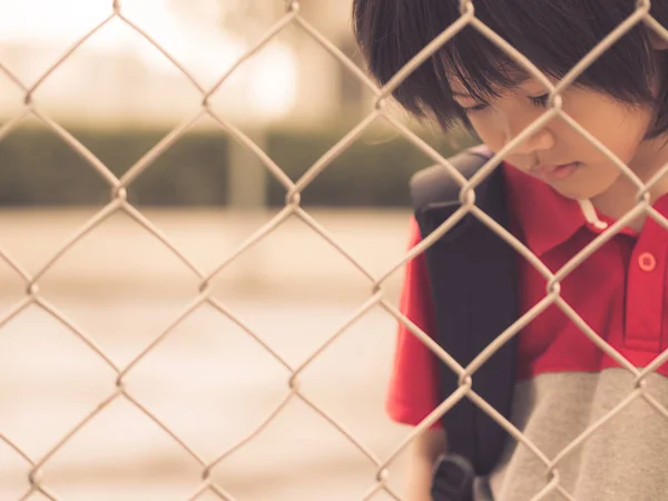 Estilo vintage de niño triste detrás de malla de malla de valla . — Foto de Stock