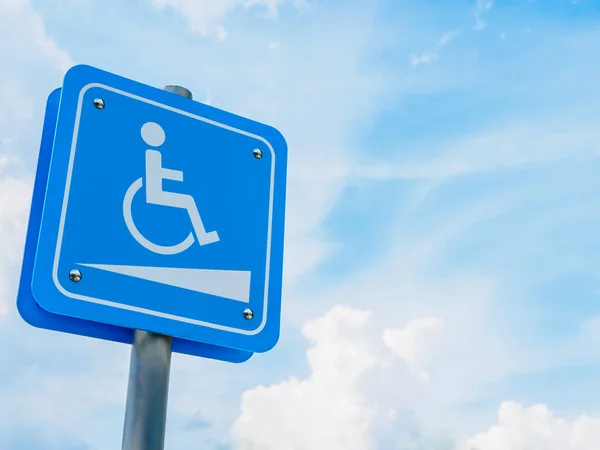 Símbolo de silla de ruedas en un estacionamiento con fondo azul y blanco del cielo . — Foto de Stock