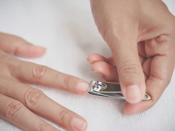 Primer plano de una mujer que corta las uñas, concepto de atención médica . — Foto de Stock