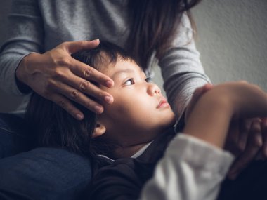 Closeup üzgün küçük çocuk annesi tarafından evde yalan. 