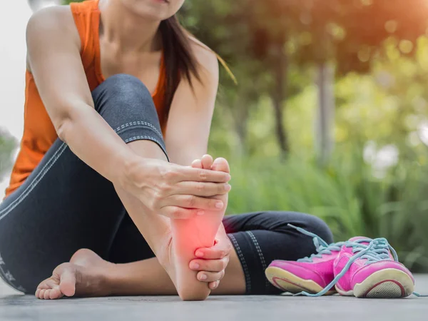 Soft focus woman massaging her painful foot while exercising. — Stock Photo, Image