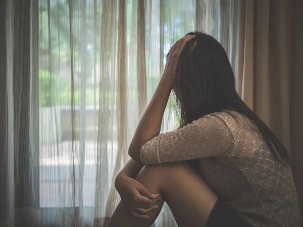 Triste donna abbracciare il ginocchio e piangere mentre seduto da solo — Foto Stock