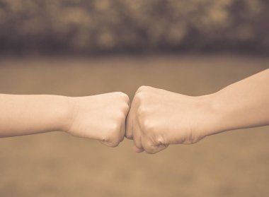 Retro anne ve oğlu yeşil arka planda yumruk çarpmak vardır. 